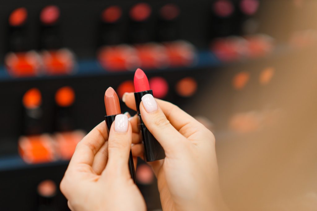 Woman choosing lipstick in cosmetics store
